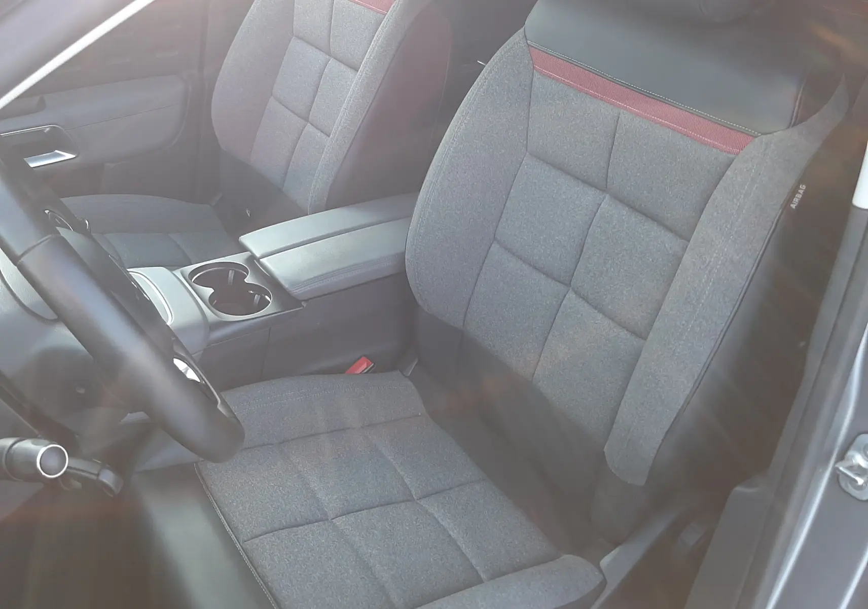 Vue intérieure côté conducteur du Citroën C5 Aircross 2021, sièges gris tissu avec bande rouge et appuis-tête noirs.