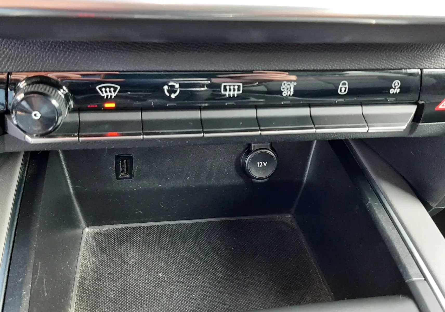 Vue rapprochée de la console centrale du Citroën C5 Aircross 2021 avec commandes climatisation et prise 12V noire.