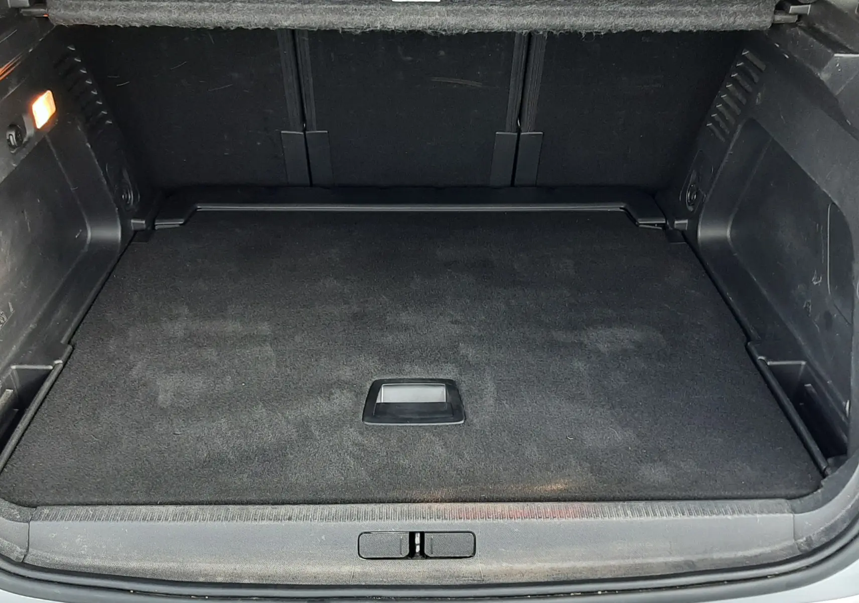 Coffre ouvert vu de l'arrière d'une Citroën C5 Aircross gris Artense, espace de chargement propre et vide.