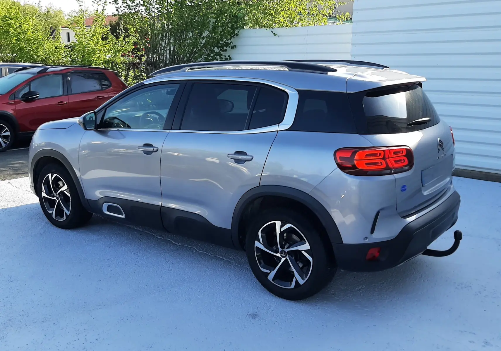 Citroën C5 Aircross gris Artense vu en 3/4 arrière côté gauche, avec toit noir et jantes noires bicolores.