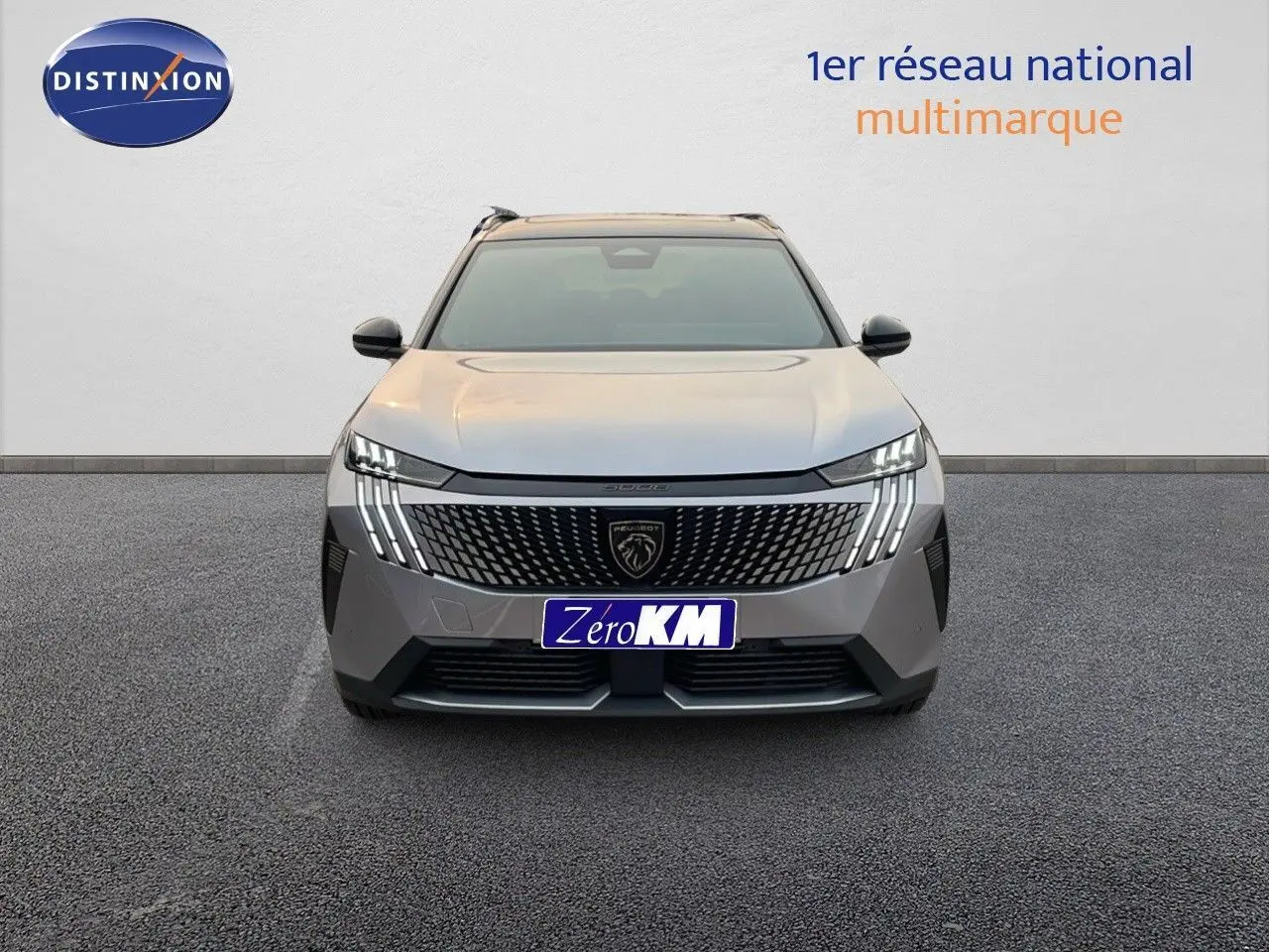 Vue frontale du Peugeot 5008 Hybrid gris Artense métal avec toit noir, mettant en valeur sa calandre et ses feux LED distinctifs.