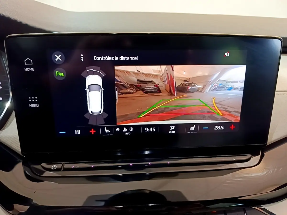 Écran tactile central du Skoda Octavia blanc 2022 montrant la caméra de recul avec guidage de trajectoire coloré.