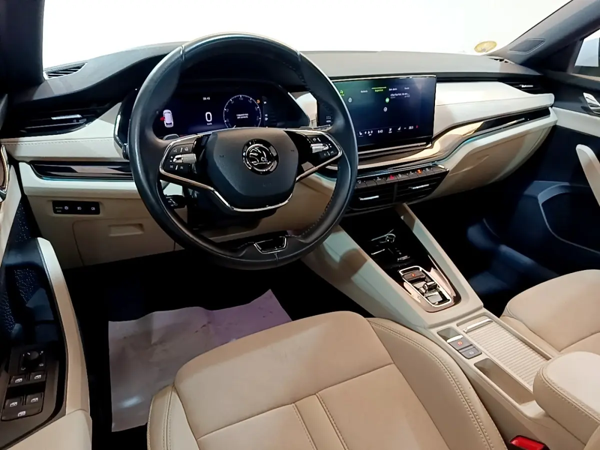 Intérieur beige clair de la Skoda Octavia 2022 vu côté conducteur, avec tableau de bord digital et écran tactile central.