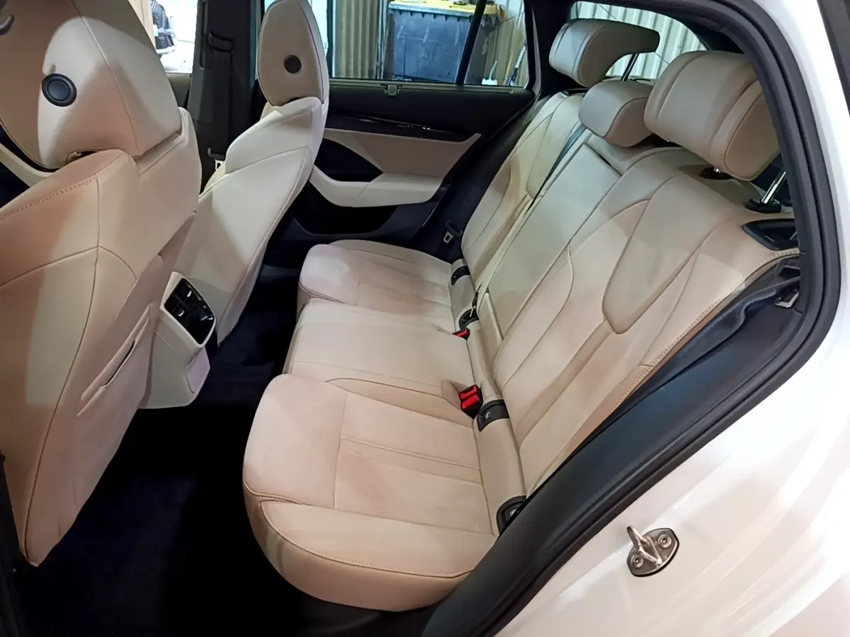 Vue intérieure côté droit des sièges arrière beige clair d'une Skoda Octavia blanche 2022 avec appuie-têtes réglables.