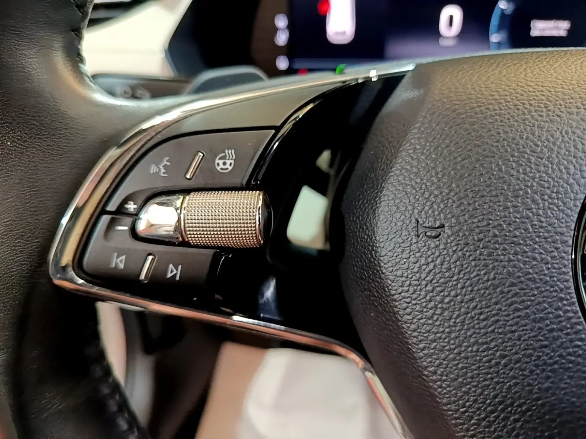 Gros plan sur la molette de contrôle et les boutons du volant noir de la Skoda Octavia 2.0 TDI 2022.