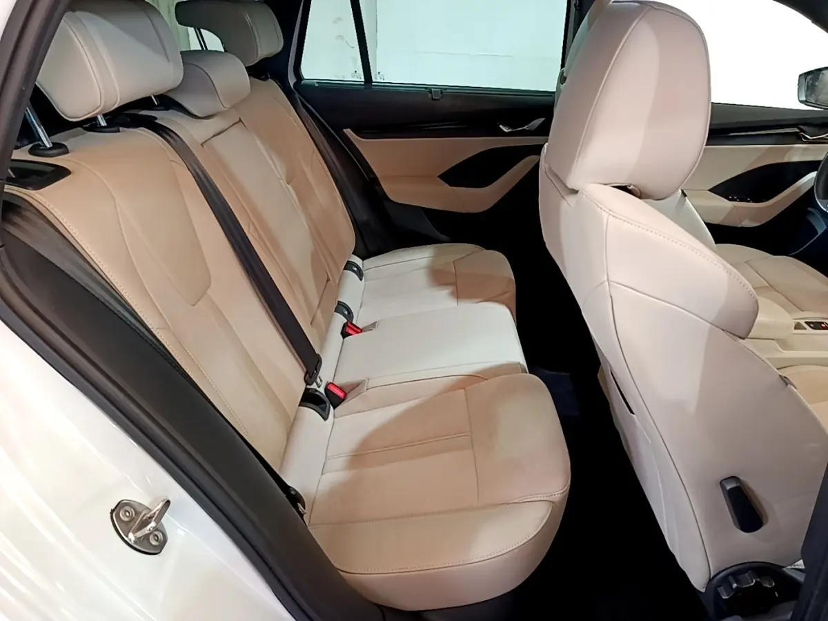 Vue intérieure côté droit montrant les sièges arrière beige clair d'une Skoda Octavia blanche 2022 Style.