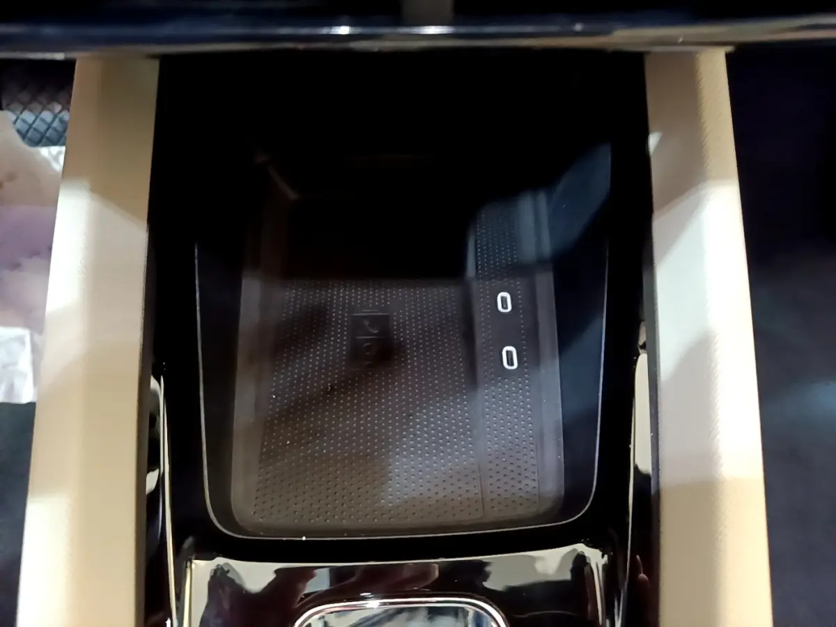 Gros plan sur la zone de recharge sans fil noire au centre de la console d'une Skoda Octavia blanche 2022.
