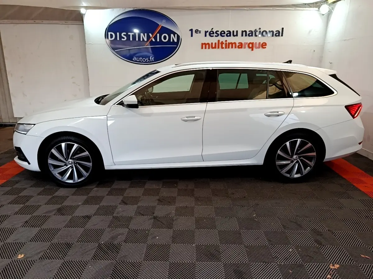 Profil latéral gauche d'une Skoda Octavia blanche 2022 en break, avec jantes alliage et vitres teintées.