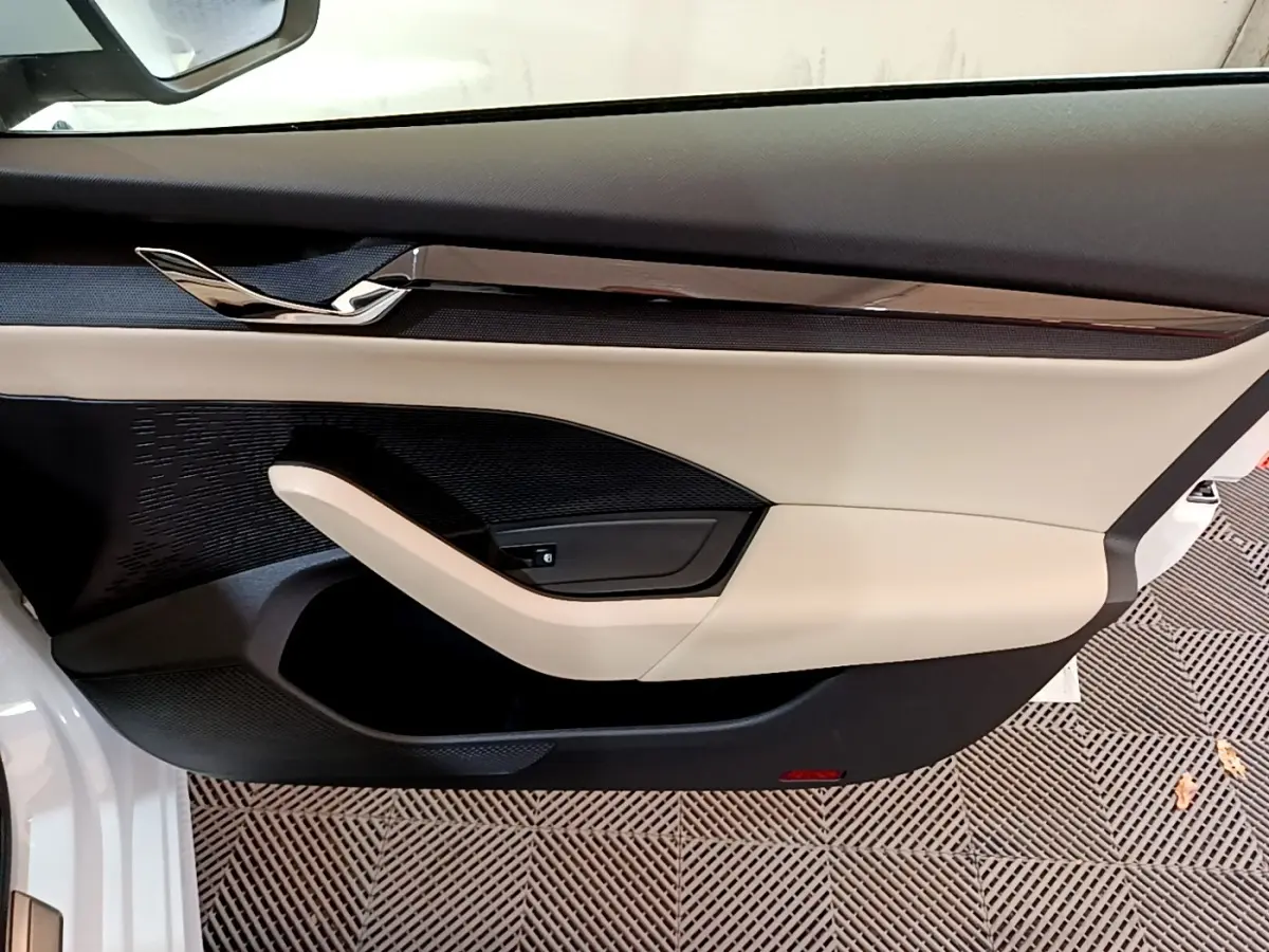 Vue rapprochée de la porte avant gauche blanche d'une Skoda Octavia 2022 avec garniture beige et noire élégante.