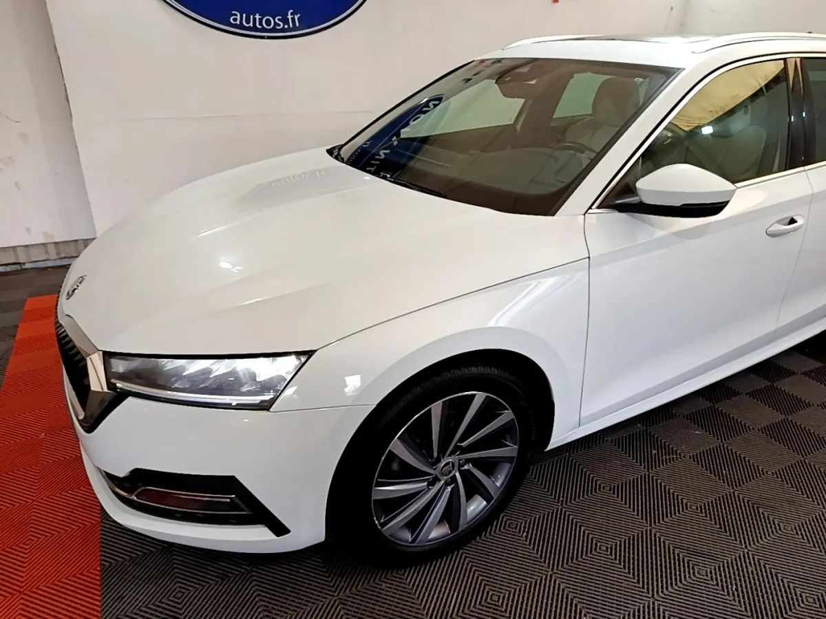 Vue 3/4 avant droit d'une Skoda Octavia blanche 2022 avec jantes alliage et phares LED distinctifs.