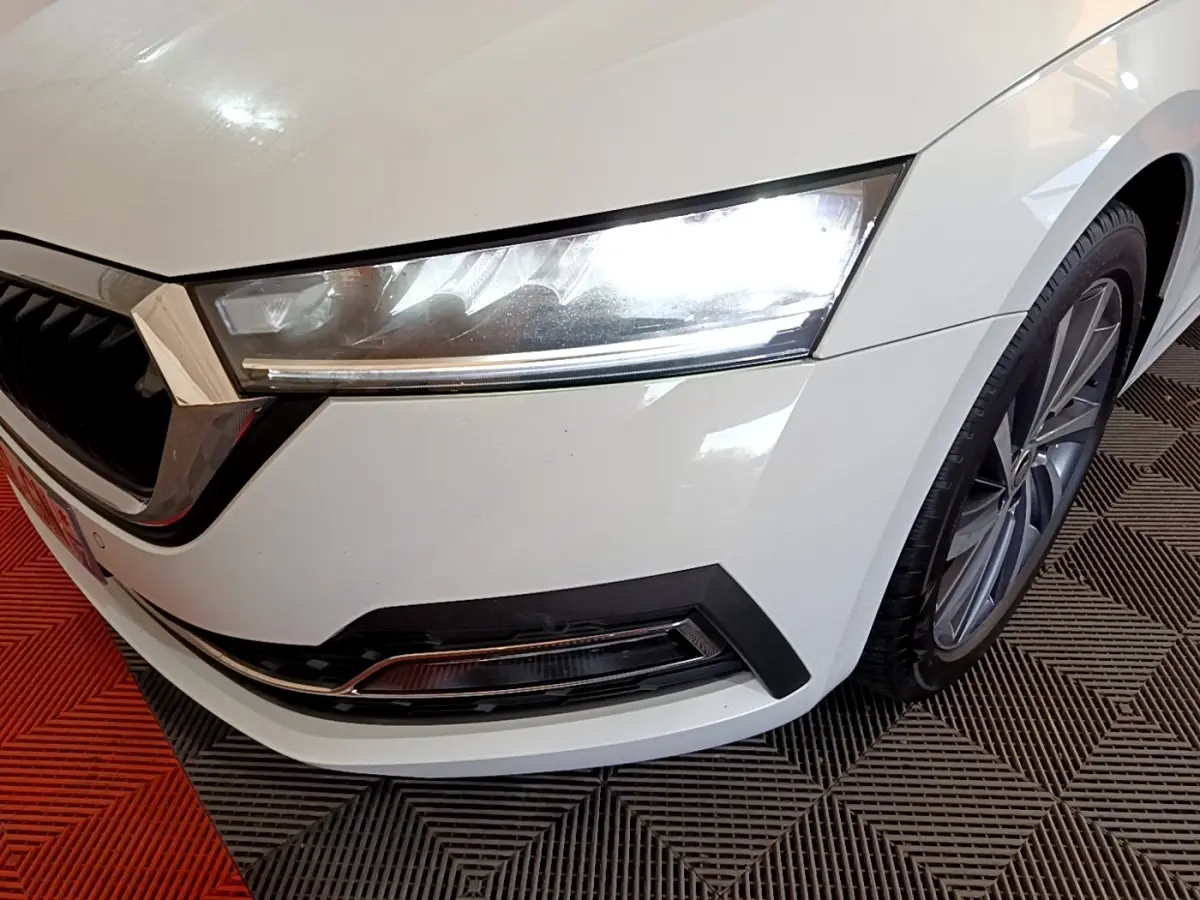 Gros plan sur l'avant droit blanc d'une Skoda Octavia 2022, mettant en valeur le phare LED et la jante alliage.
