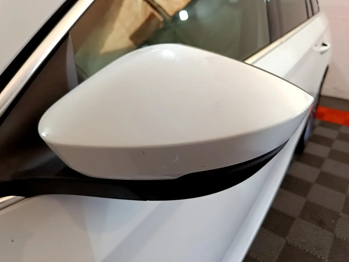 Rétroviseur blanc côté gauche en gros plan d'une Skoda Octavia 2.0 TDI 150 DSG7 Style 2022 blanche.