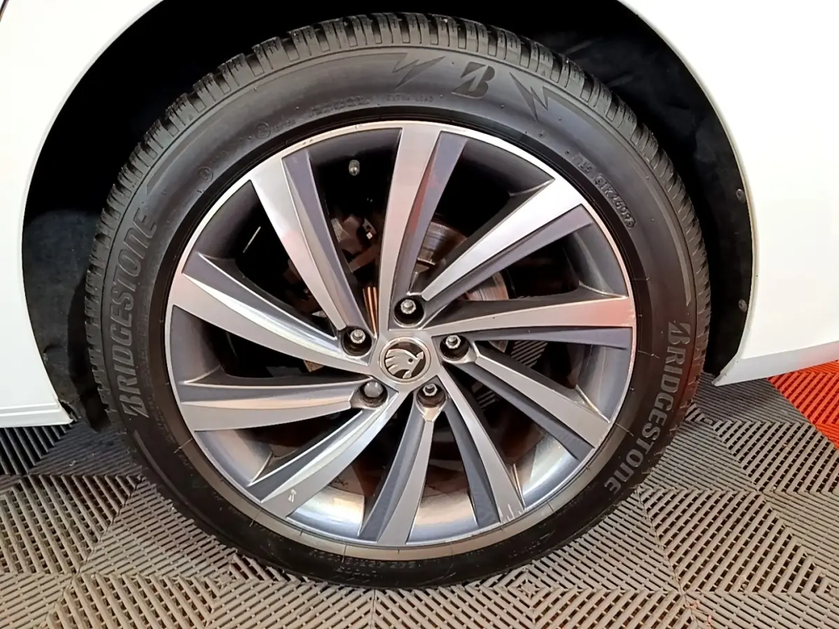Gros plan sur la roue avant droite blanche d'une Skoda Octavia 2.0 TDI 150 DSG7 Style avec jante alliage gris et pneu Bridgestone.