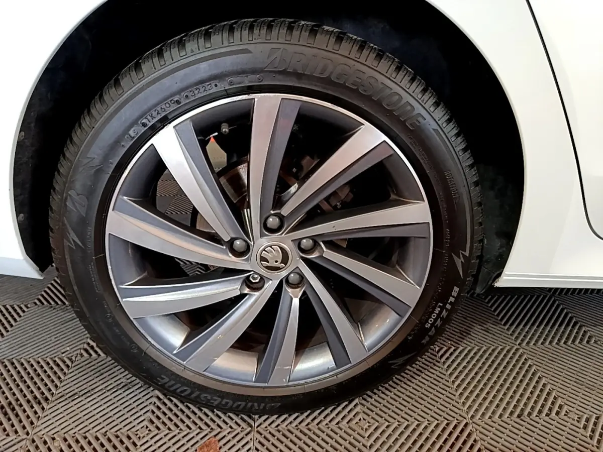 Gros plan sur la roue avant droite d'une Skoda Octavia blanche 2022 avec jante alliage et pneu Bridgestone.