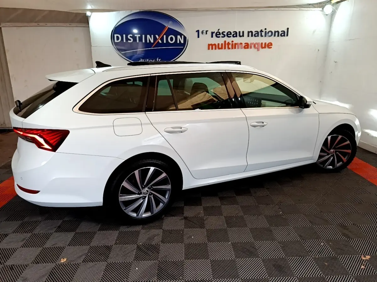 Vue latérale droite d'une Skoda Octavia break blanche 2022 avec jantes alliage et feux arrière LED distinctifs.