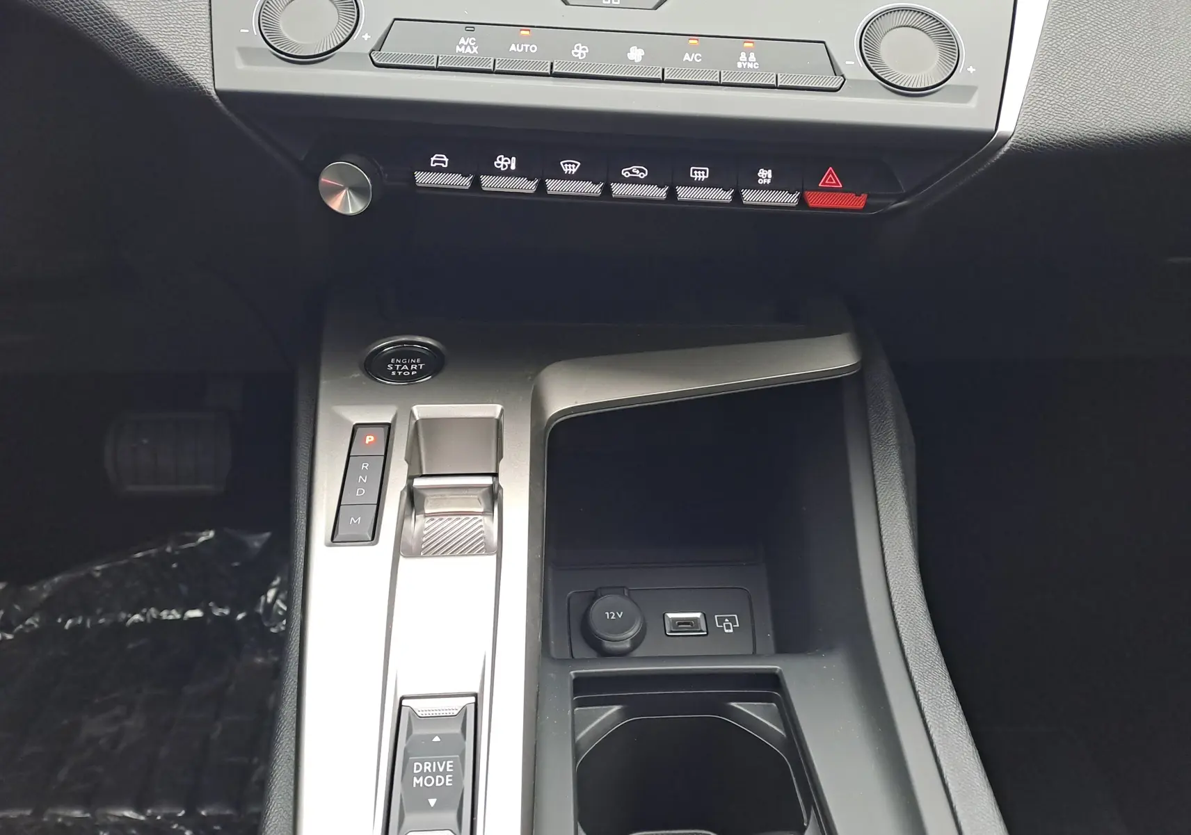 Vue rapprochée de la console centrale de la Peugeot 308 blanche, montrant la commande de boîte auto et les boutons de climatisation.