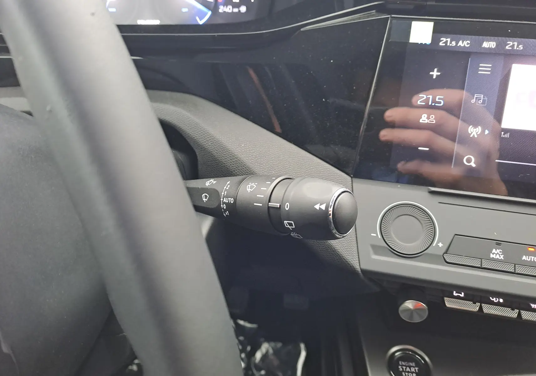 Gros plan sur la commande d’essuie-glace à gauche du volant dans l’habitacle sombre d’une Peugeot 308 blanche 2025.