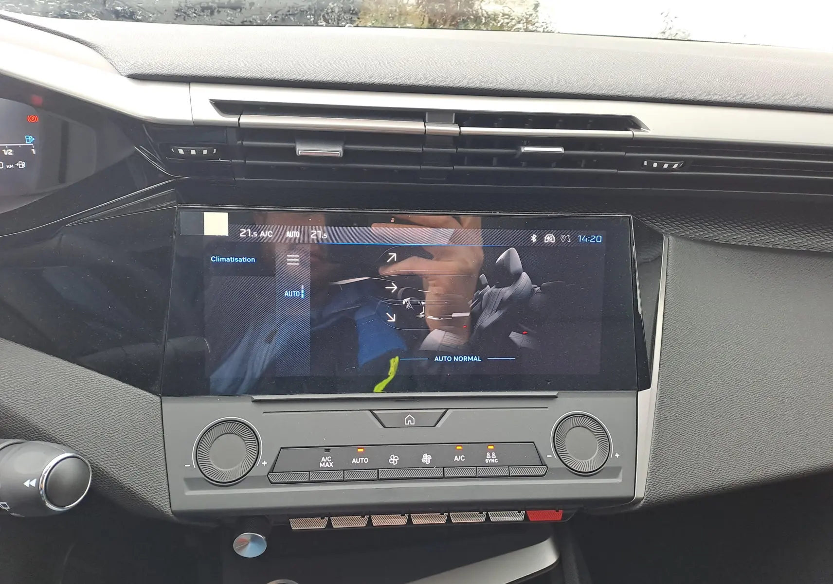 Vue rapprochée de la console centrale et écran tactile de la Peugeot 308 2025, avec commandes de climatisation visibles.