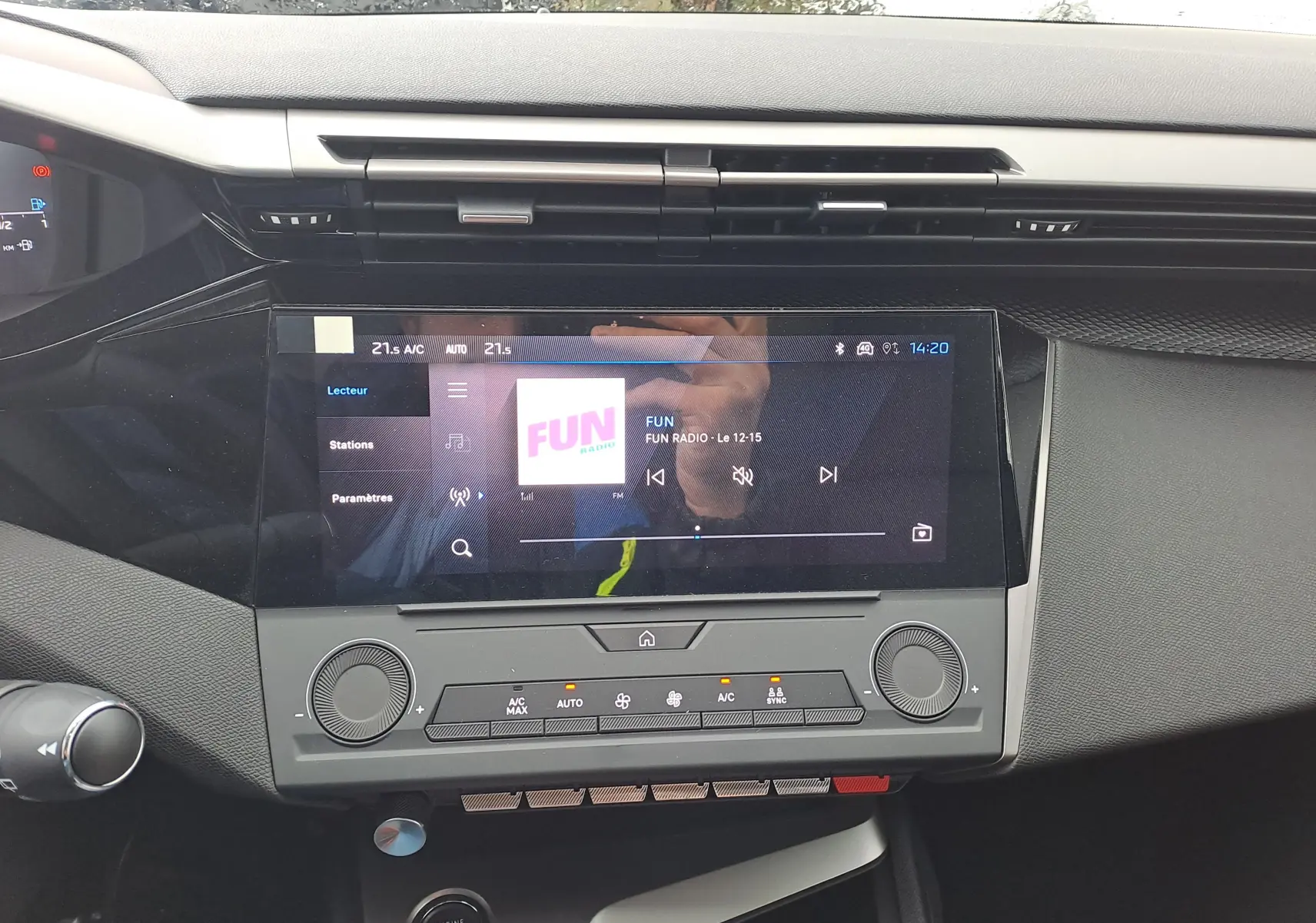 Vue rapprochée du tableau de bord de la Peugeot 308 blanc Okenite 2025, avec écran tactile central et commandes climatisation.