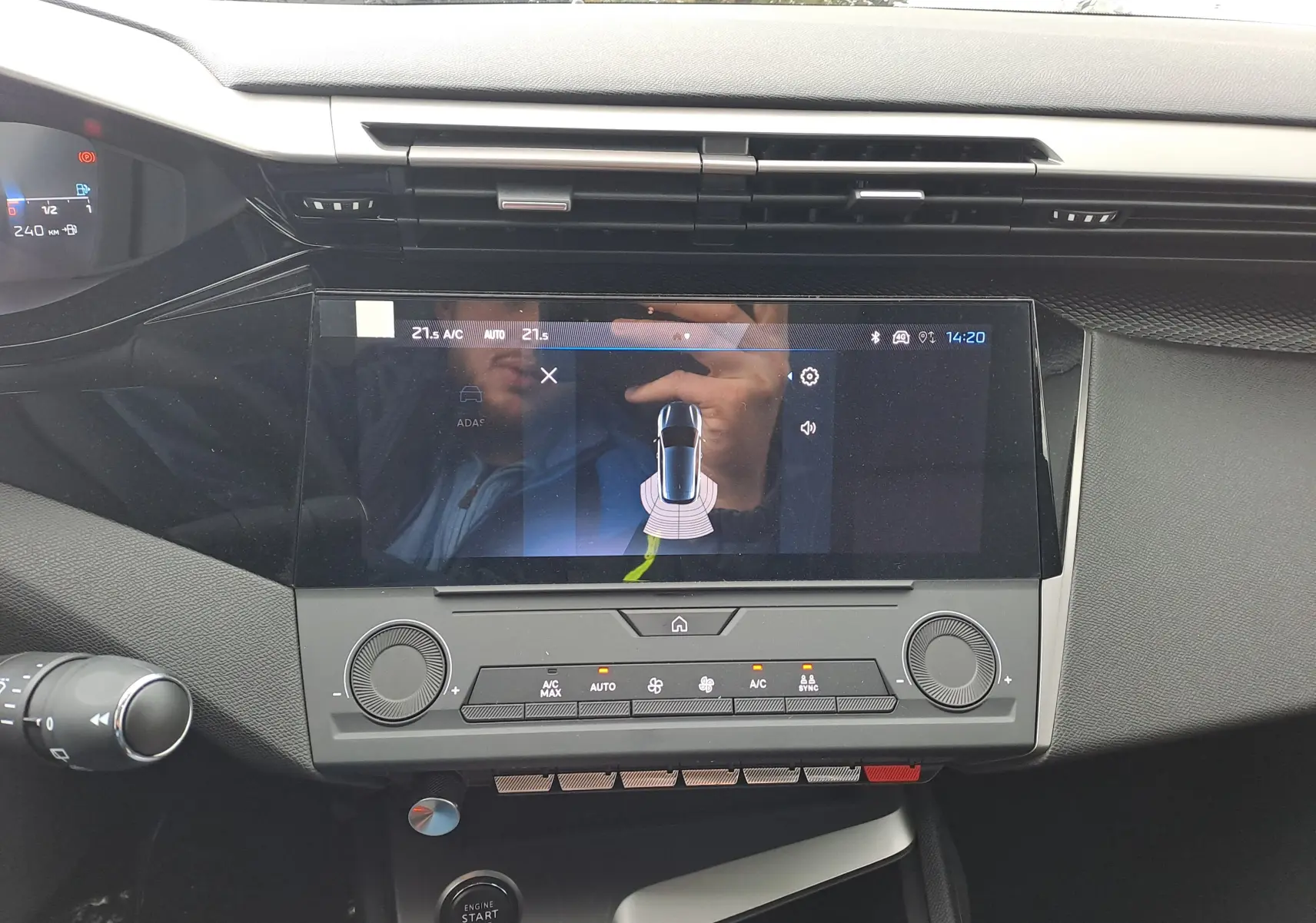 Vue rapprochée de la console centrale de la Peugeot 308 2025, écran tactile affichant l'aide au stationnement.