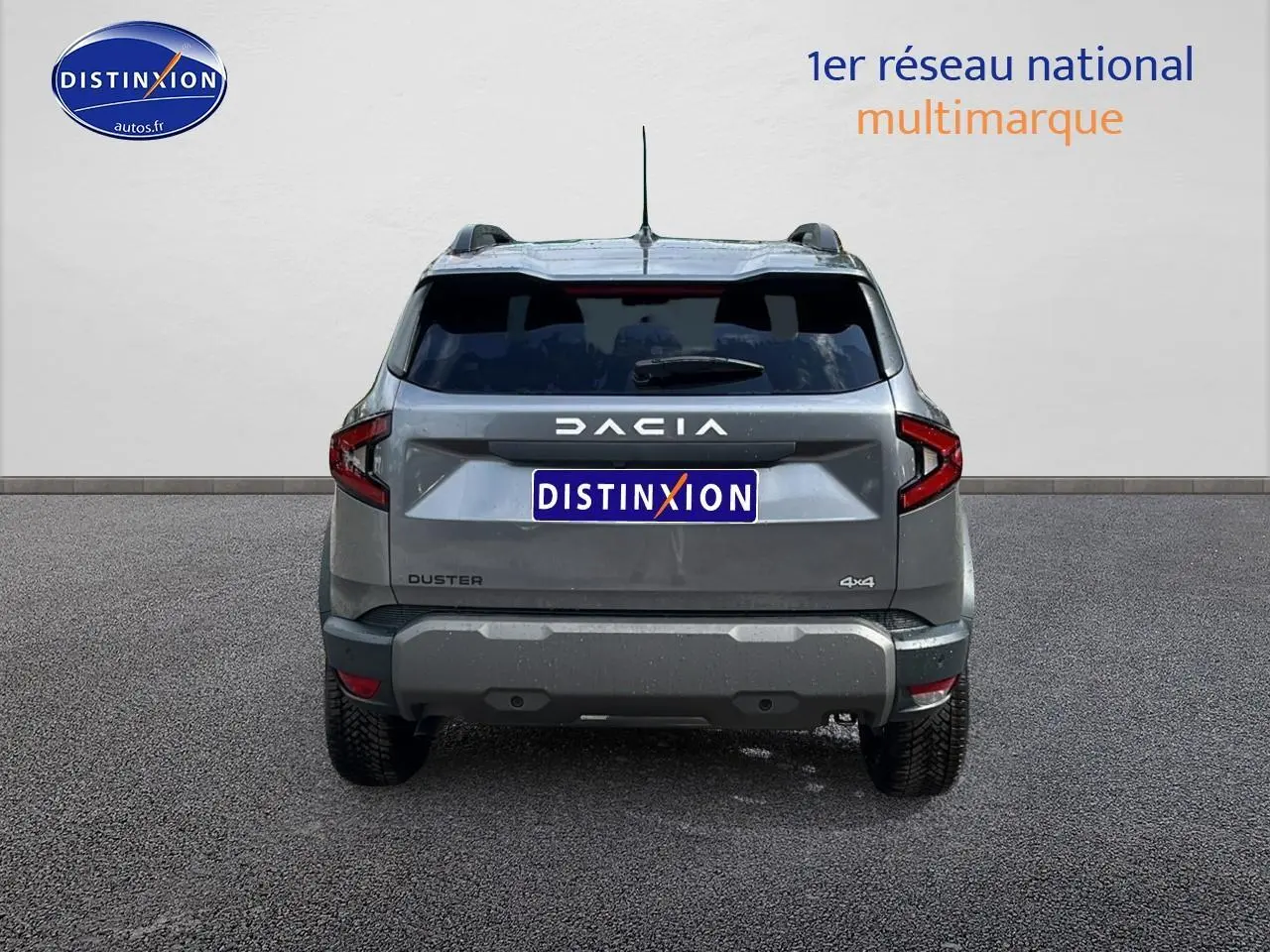 Vue arrière du Dacia Duster gris schiste 2025 avec logo DACIA et badge 4x4 visible sur un fond neutre.