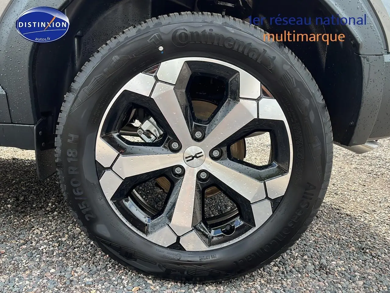 Gros plan sur la roue avant droite du Dacia Duster gris schiste, jante alu bicolore et pneu Continental.