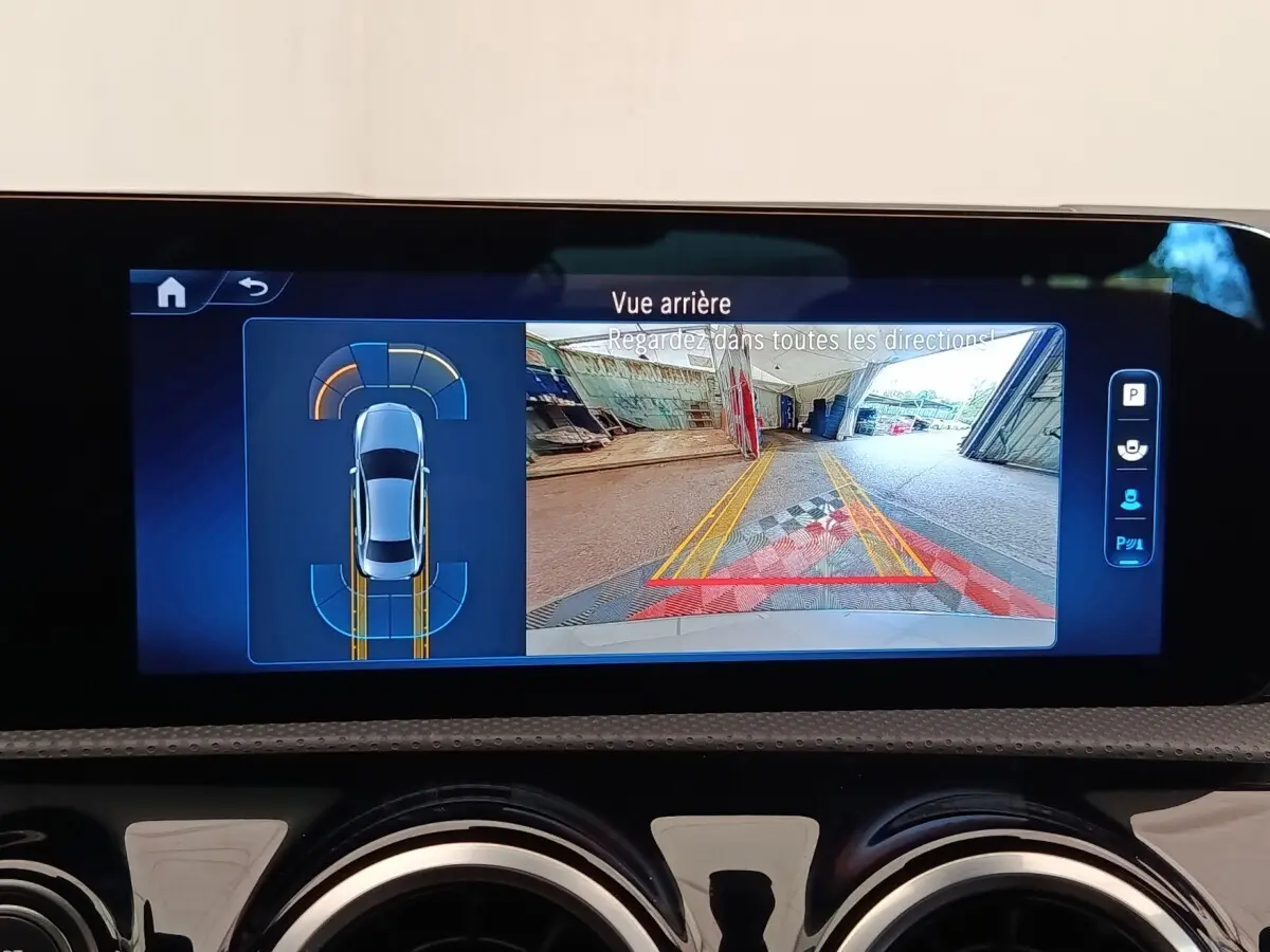 Écran tactile intérieur montrant la caméra de recul et l’aide au stationnement d’une Mercedes Classe A 250 e hybride.