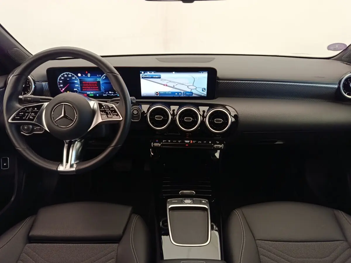 Vue intérieure avant de la Mercedes Classe A 250 e Hybrid avec tableau de bord numérique et écran tactile central.