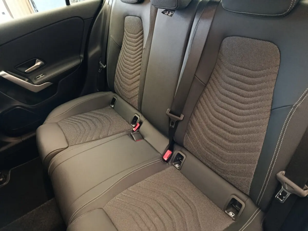 Vue intérieure de la banquette arrière noire avec surpiqûres et ceintures de sécurité de la Mercedes Classe A 250 e Hybrid.