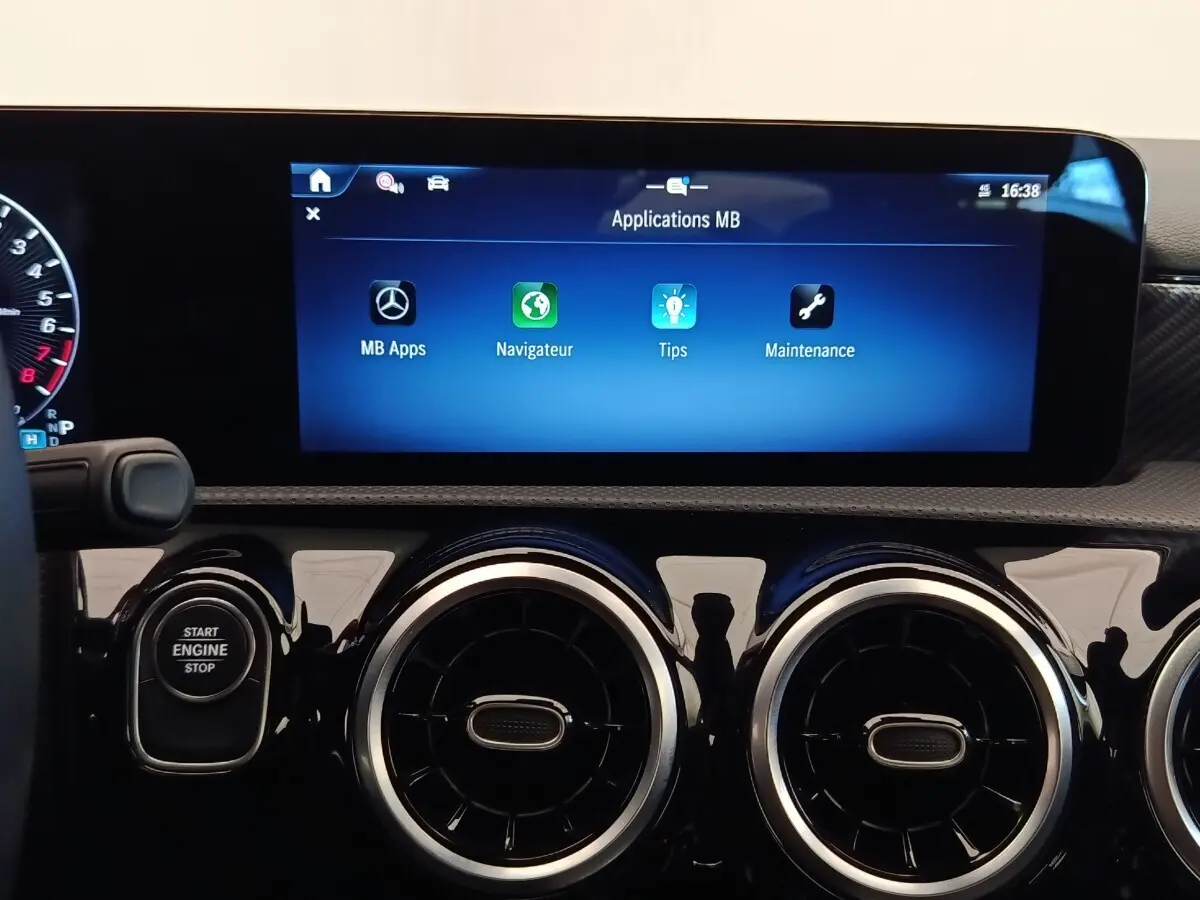 Vue rapprochée du tableau de bord noir brillant de la Mercedes Classe A 250 e Hybrid avec écran tactile multifonctions allumé.