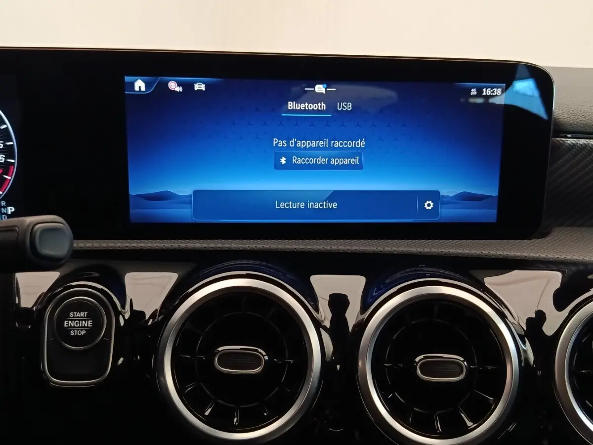 Tableau de bord noir brillant de Mercedes Classe A 250 e Hybrid avec écran tactile multifonctions allumé.