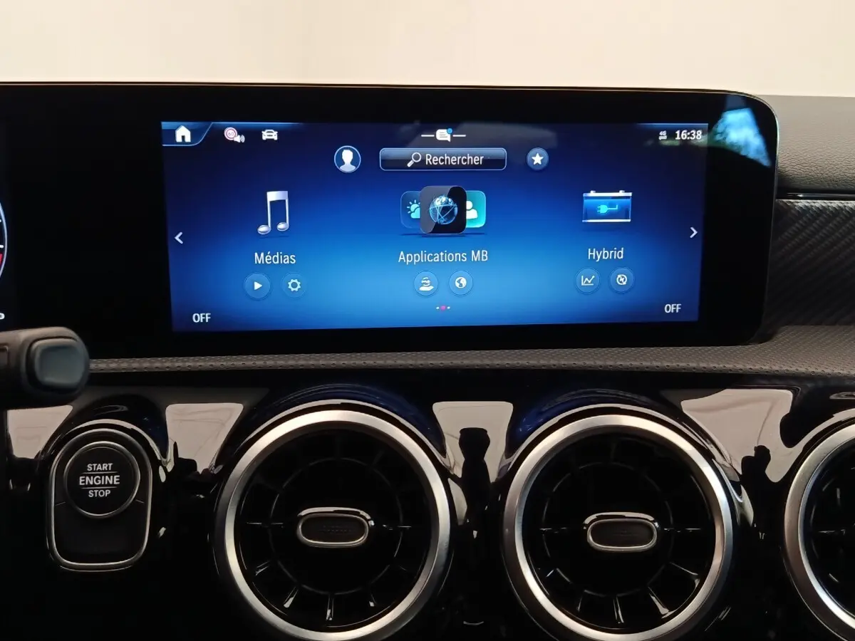 Vue rapprochée du tableau de bord noir brillant de la Mercedes Classe A 250 e Hybrid avec écran tactile multifonctions allumé.