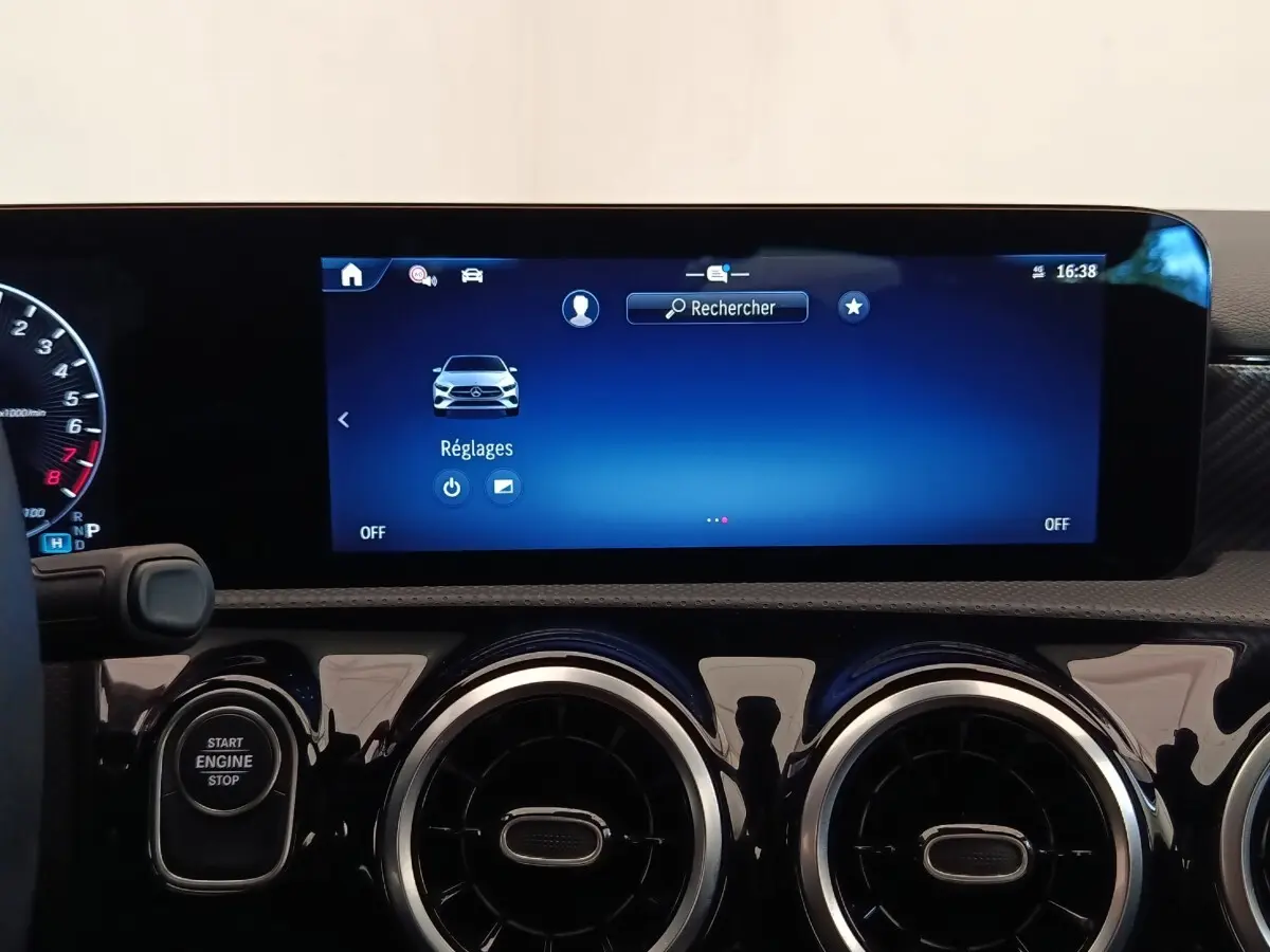 Vue rapprochée du tableau de bord de la Mercedes Classe A 250 e Hybrid avec écran tactile bleu et aérateurs ronds noirs.