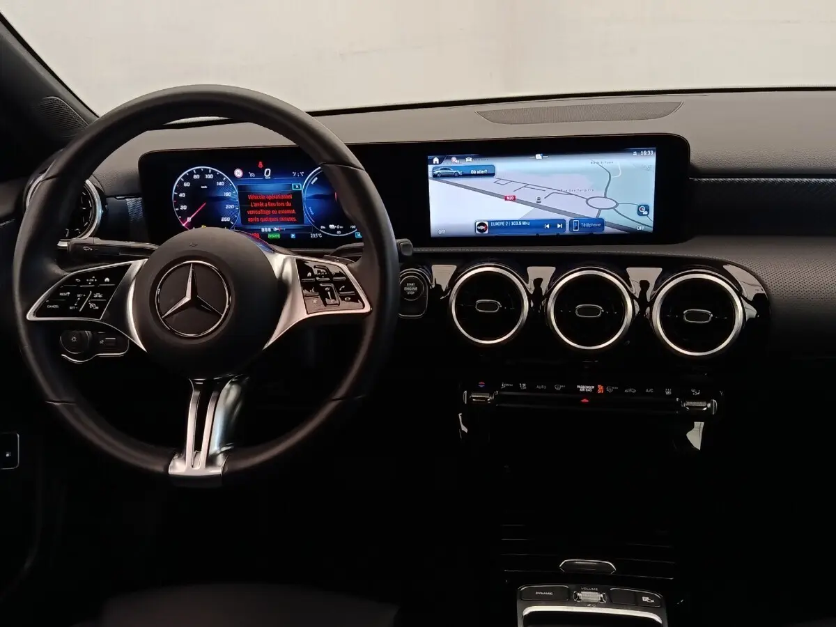 Vue intérieure frontale du tableau de bord de la Mercedes Classe A 250 e Hybrid avec écran tactile large et volant multifonctions.