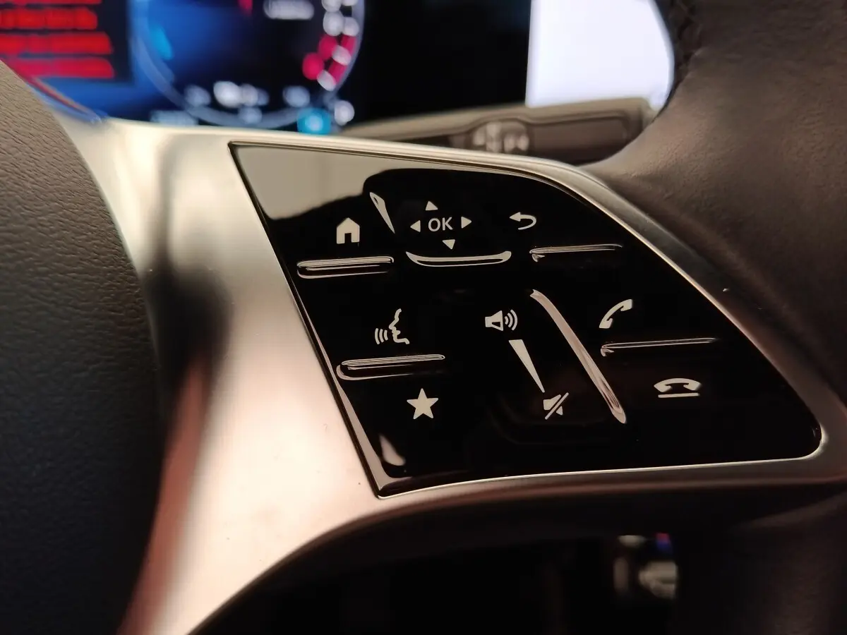 Gros plan sur les commandes tactiles noires du volant côté gauche d’une Mercedes Classe A 250 e hybride 2024.