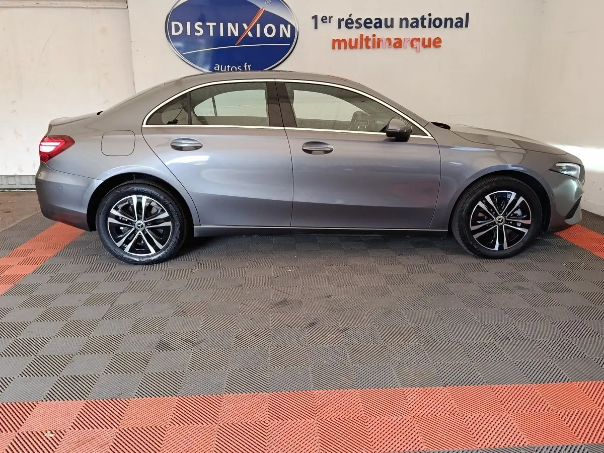 Profil côté gauche d'une Mercedes Classe A 250 e Hybrid gris foncé, avec jantes alliage et feux arrière LED visibles.