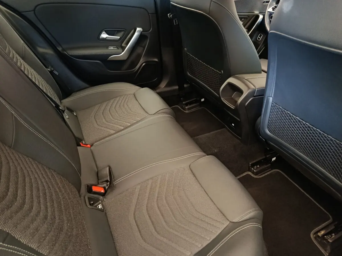 Vue intérieure arrière côté droit de la Mercedes Classe A 250 e Hybrid gris foncé, montrant la banquette et les dossiers des sièges avant.