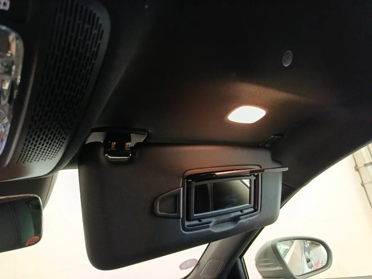 Détail intérieur du pare-soleil côté conducteur avec miroir éclairé et rétroviseur extérieur gris foncé d'une Mercedes Classe A 250 e Hybrid.