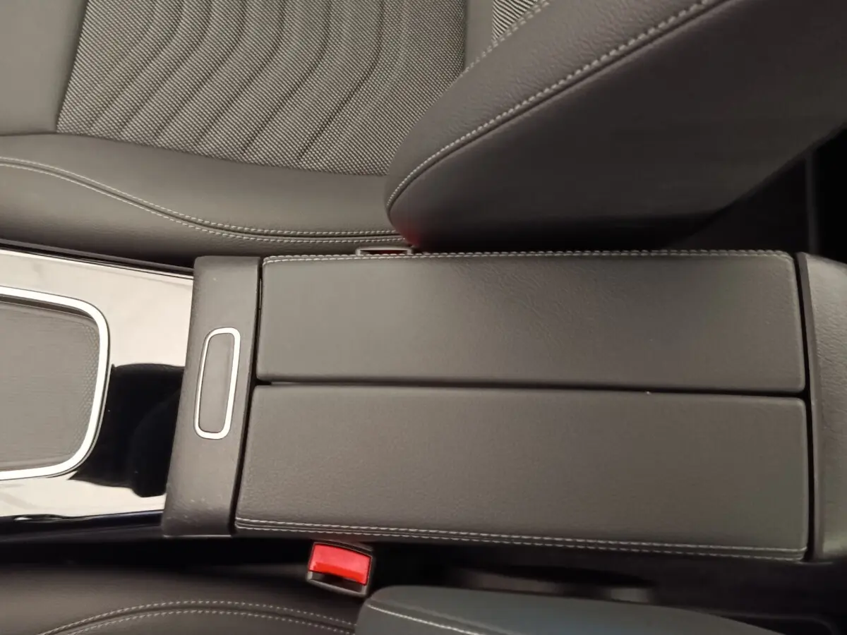 Gros plan sur l'accoudoir central en cuir noir avec surpiqûres blanches de la Mercedes Classe A 250 e Hybrid 2024.