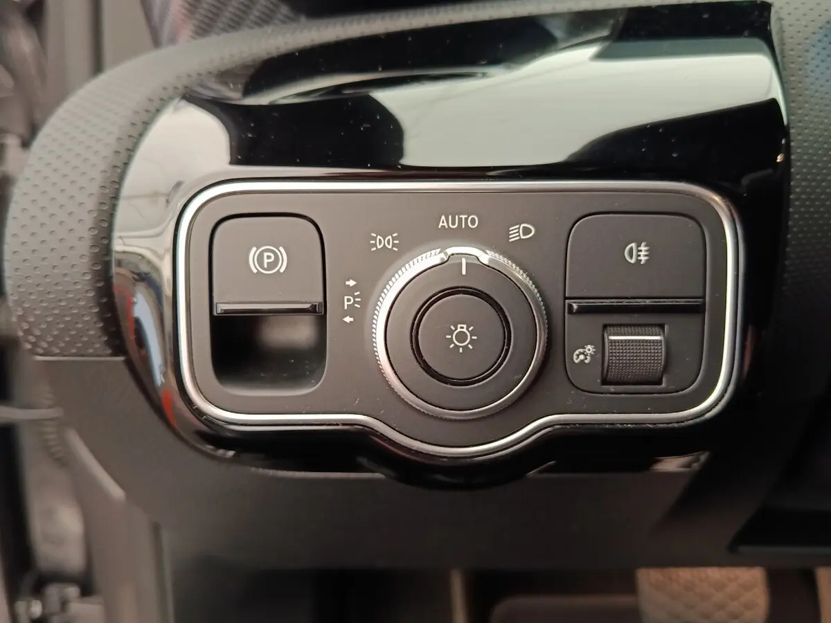Gros plan sur le panneau de commandes d’éclairage et frein à main électrique de la Mercedes Classe A 250 e hybride 2024.