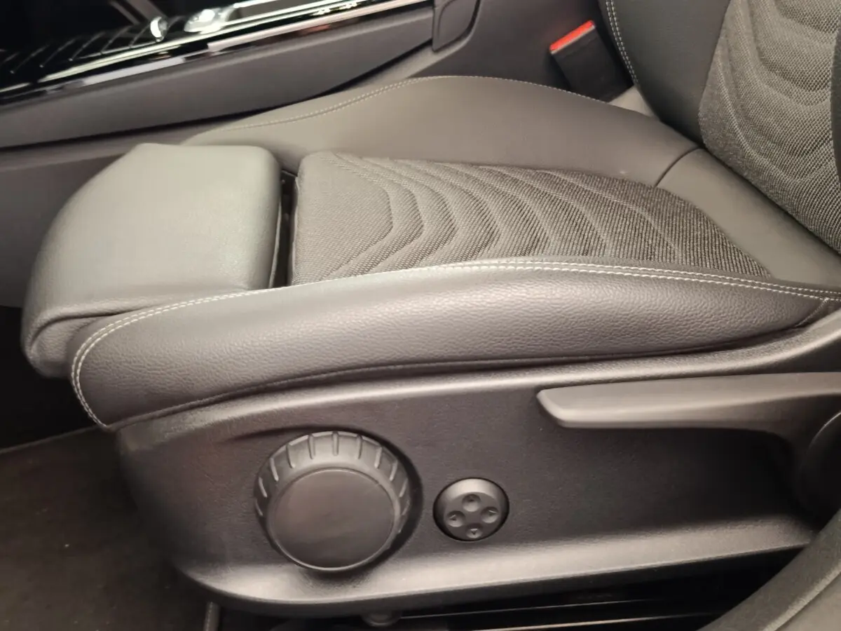 Gros plan sur le siège avant gris foncé de la Mercedes Classe A 250 e Hybrid avec commandes de réglage manuelles.