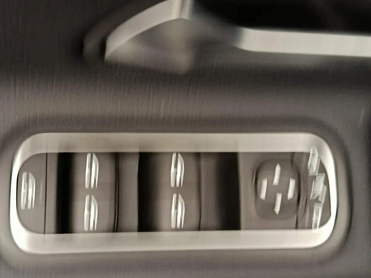 Gros plan sur les commandes de lève-vitres et réglages des rétroviseurs côté conducteur de la Mercedes Classe A 250 e hybride.