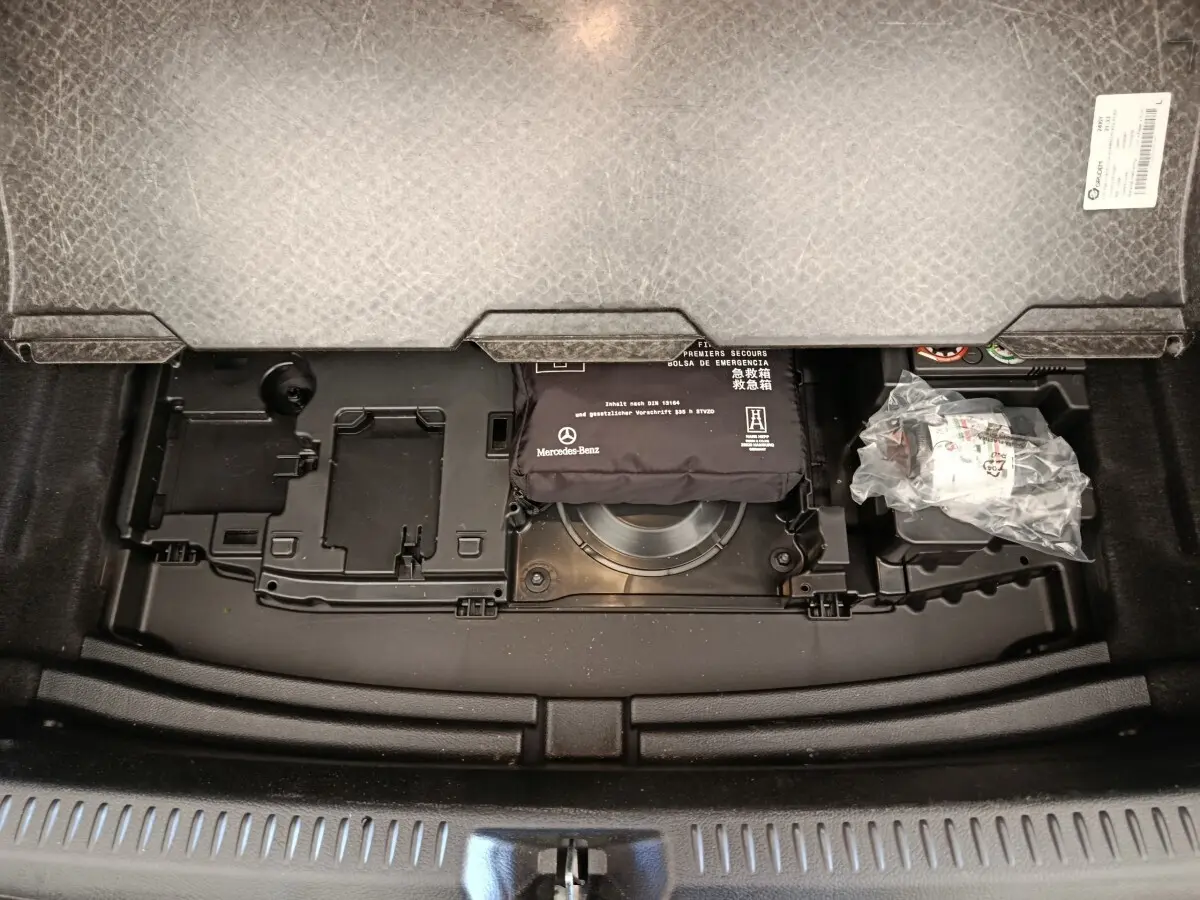 Vue plongeante sur le compartiment de rangement sous le plancher du coffre de la Mercedes Classe A 250 e gris foncé.