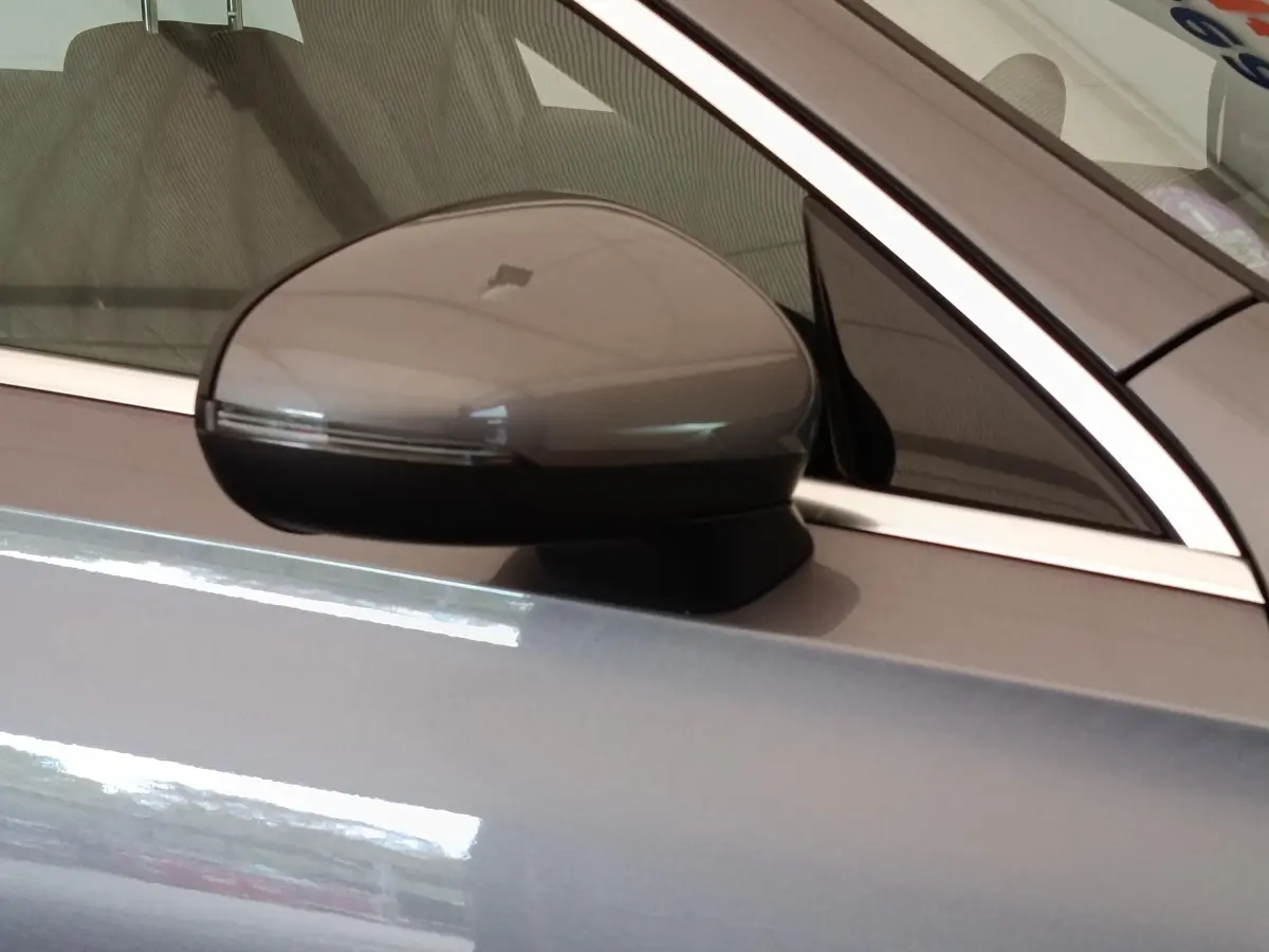 Rétroviseur côté conducteur gris foncé de la Mercedes Classe A 250 e Hybrid EQ Berline 2024, vue rapprochée.
