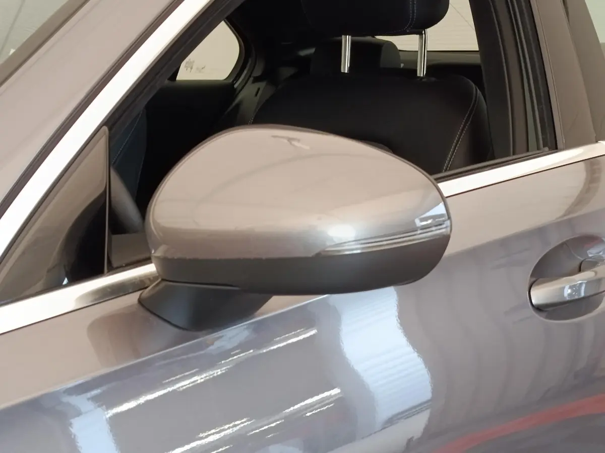 Gros plan sur le rétroviseur côté gauche gris foncé d'une Mercedes Classe A 250 e Hybrid Berline 2024.