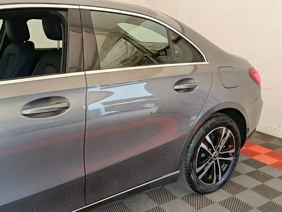 Vue latérale droite d'une Mercedes Classe A 250 e Hybrid gris foncé, mettant en valeur la jante alliage et les poignées de porte.