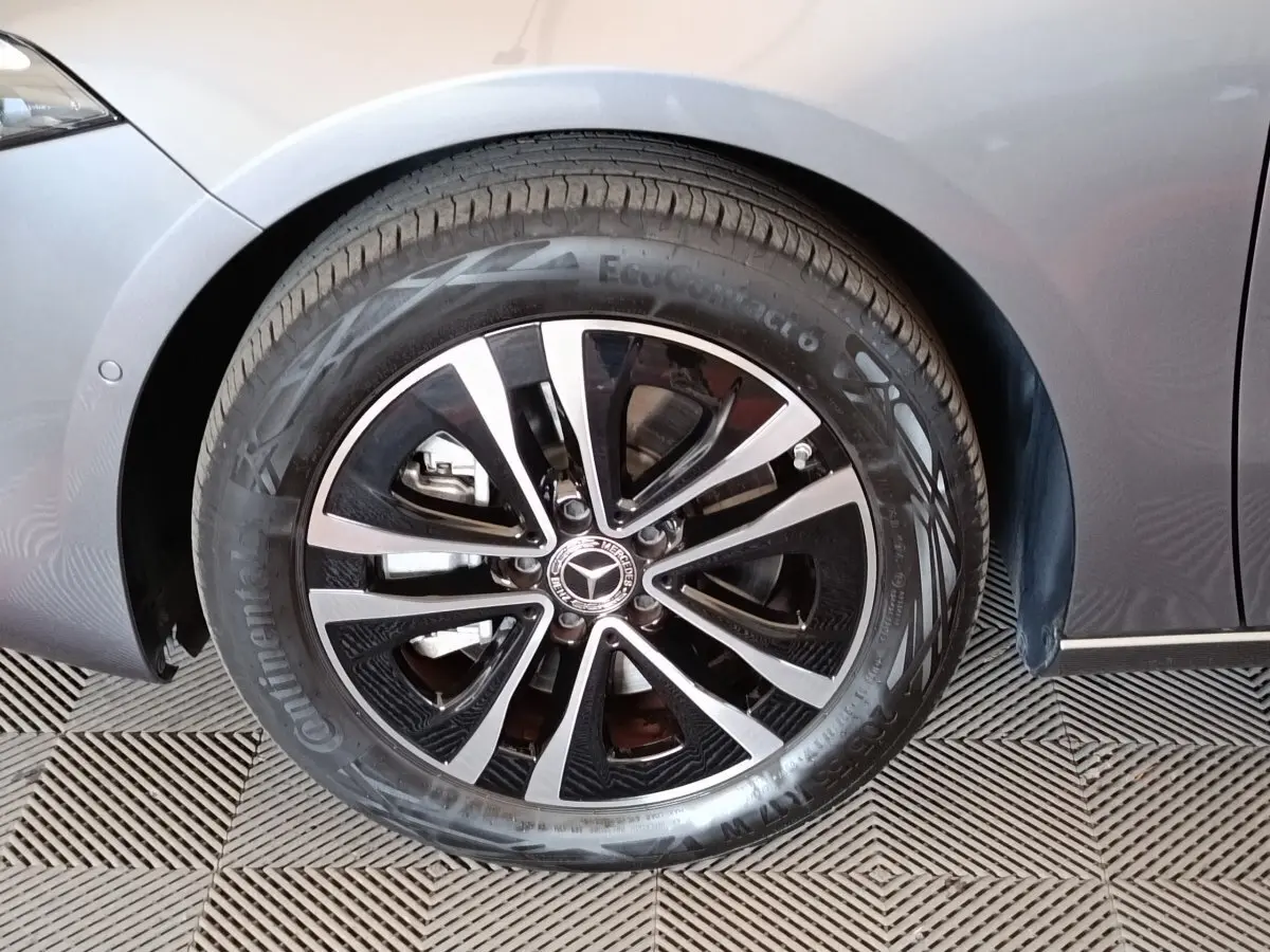 Gros plan sur la roue avant droite d'une Mercedes Classe A 250 e hybride gris foncé avec jante alliage bicolore.