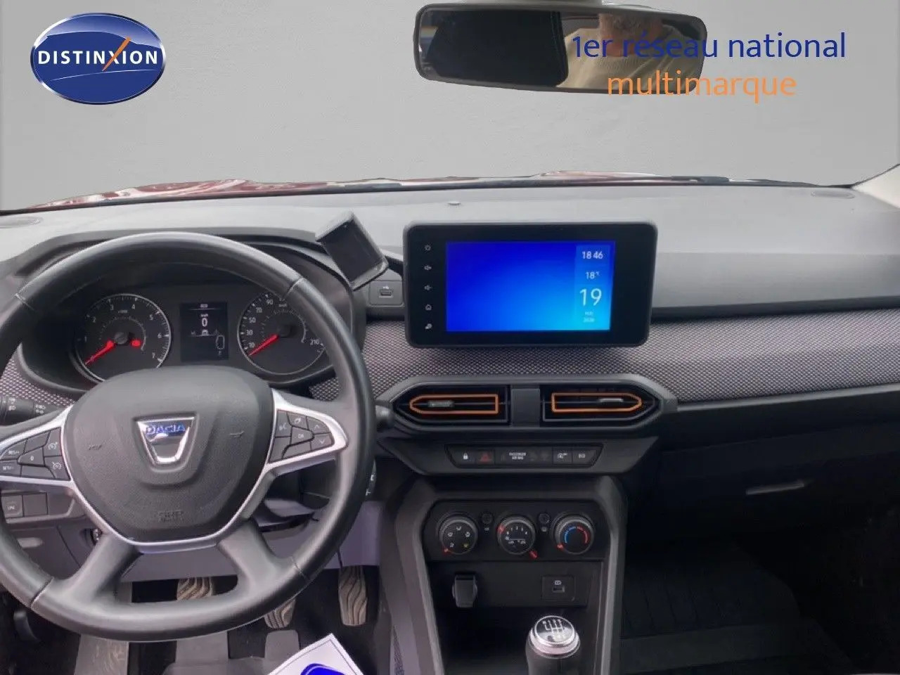 Vue intérieure frontale du tableau de bord et volant noir du Dacia Sandero Eco-G 2022, avec écran tactile central allumé.