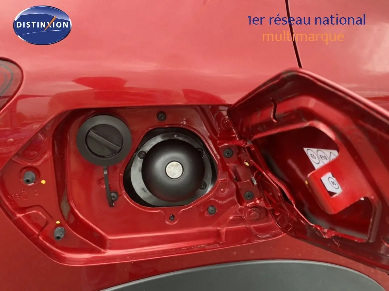 Gros plan sur la trappe à carburant rouge fusion métal de la Dacia Sandero Stepway 2022, montrant l’ouverture et les bouchons.