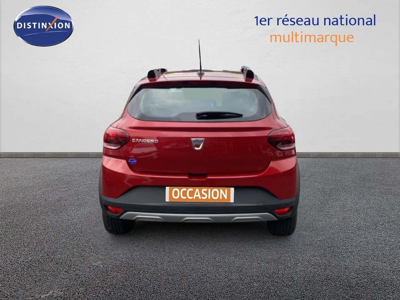 Vue arrière d'une Dacia Sandero Stepway rouge fusion métal avec logo et plaque occasion visible.